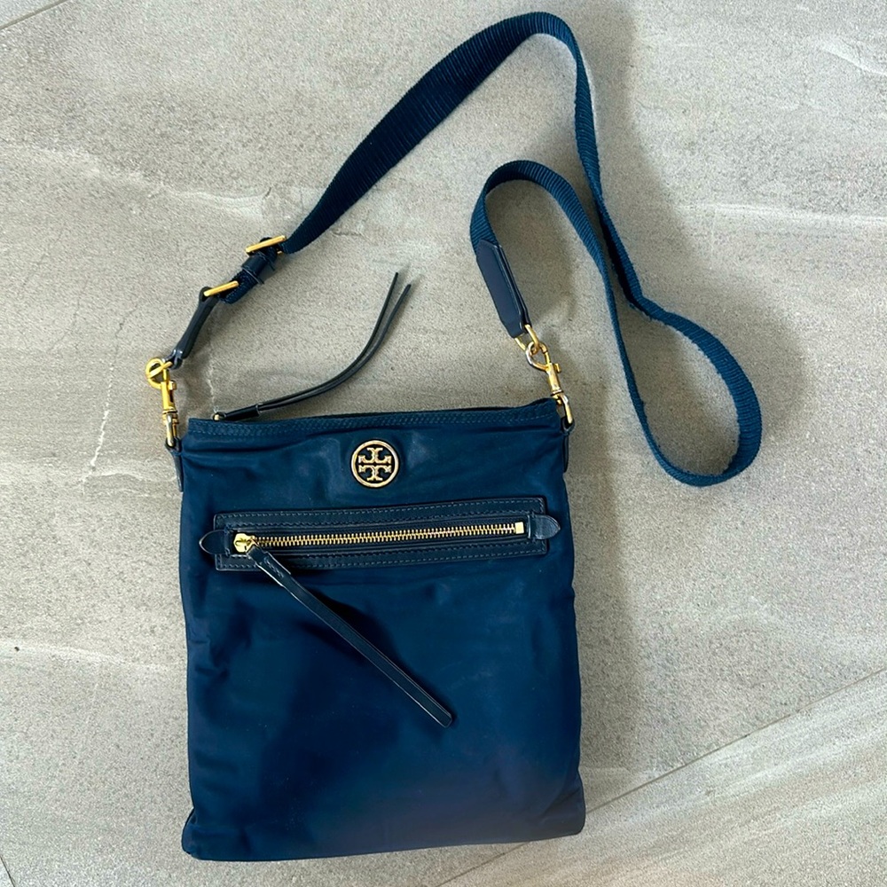 Navy blue Tory Burch nylon crossbody bag with adjustable strap.Emblem is in gold